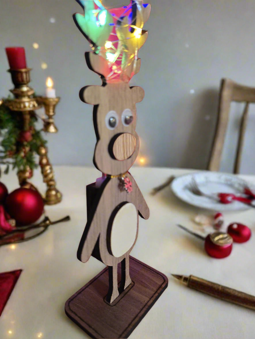 Wooden reindeer decoration with LED lights on a red background